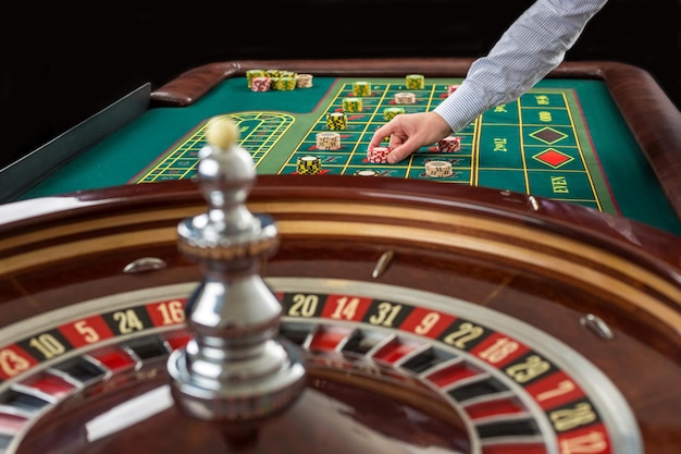 Roulette e mucchi di fiches di gioco su un tavolo verde nel casinò.