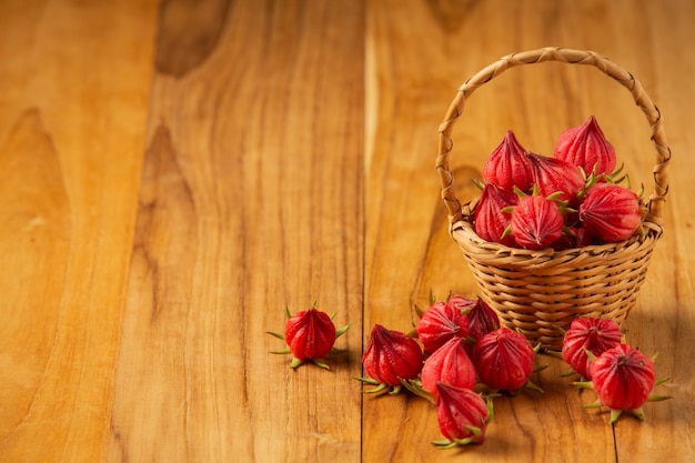 Sabdariffa fresco ibisco o rosella in una piantina posta su un vecchio pavimento di legno.