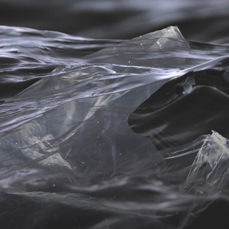 Foto gratuito sacchetti di plastica nell'oceano nero