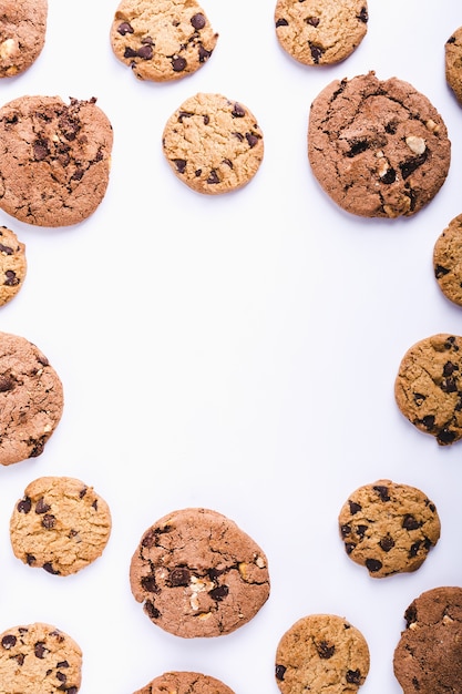 Sacco di biscotti al cioccolato disposti in cerchio su uno sfondo bianco con uno spazio di copia