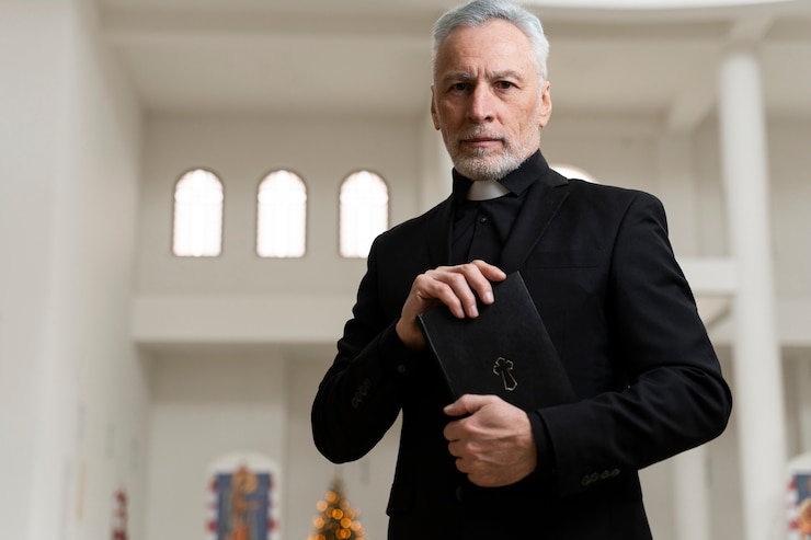 Foto gratuito sacerdote senior del colpo medio che tiene la bibbia
