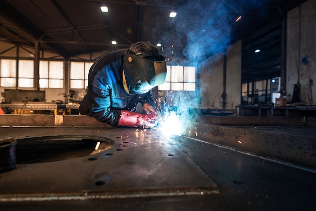 Saldatore industriale professionale saldatura di parti metalliche in fabbrica di lavorazione dei metalli