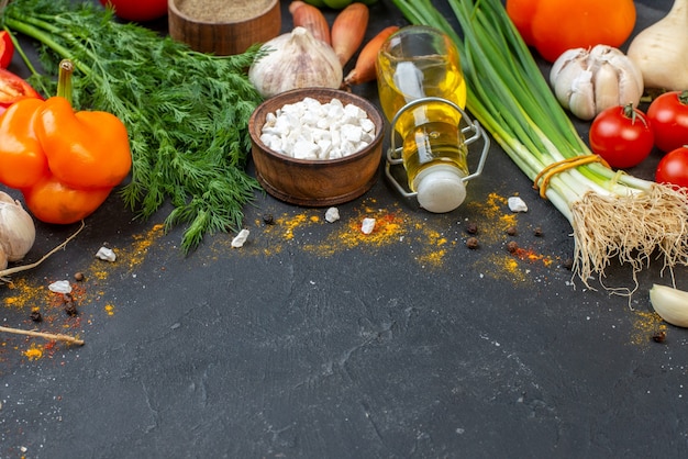 Sale marino delle verdure fresche di vista dal basso in una piccola bottiglia di olio della ciotola sulla tavola