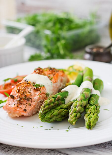 Salmone al forno guarnito con asparagi e pomodori alle erbe