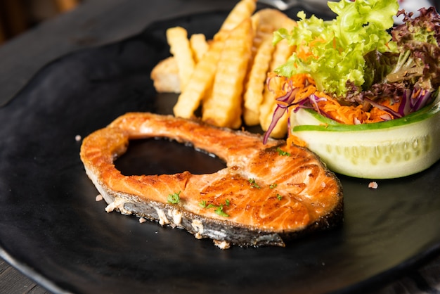 Salmone alla griglia con patatine fritte e insalata