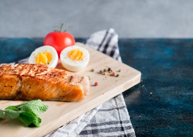 Salmone arrosto con uovo sodo sul tavolo blu