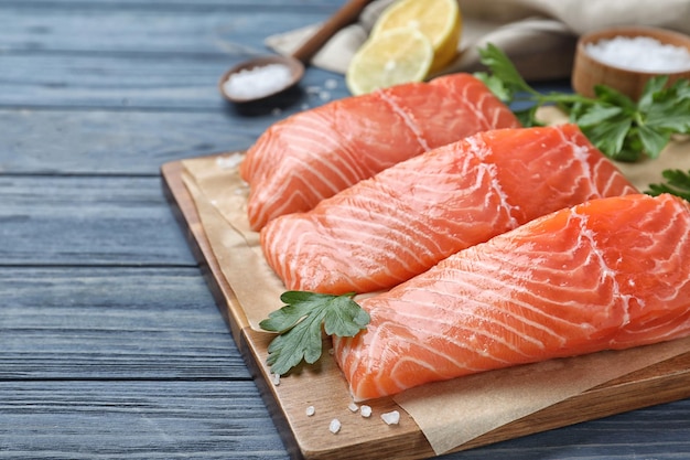 Salmone crudo fresco con prezzemolo su tavola di legno blu Delicatezza di pesce