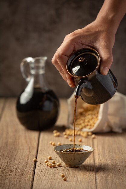 Salsa di soia e soia sul pavimento in legno Salsa di soia Concetto di nutrizione alimentare.