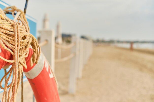 Salvagente rosso sul fuoco selettivo della spiaggia con spazio per testo