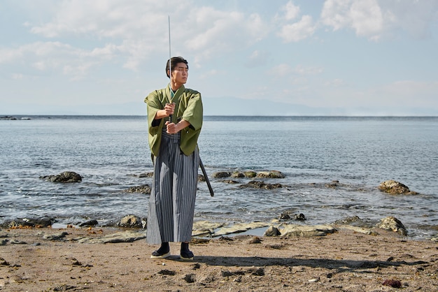 Samurai con la spada in spiaggia