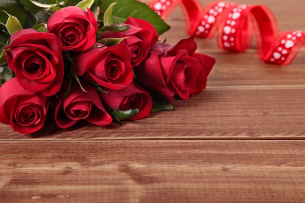 San Valentino rose rosse e nastro su tavola di legno