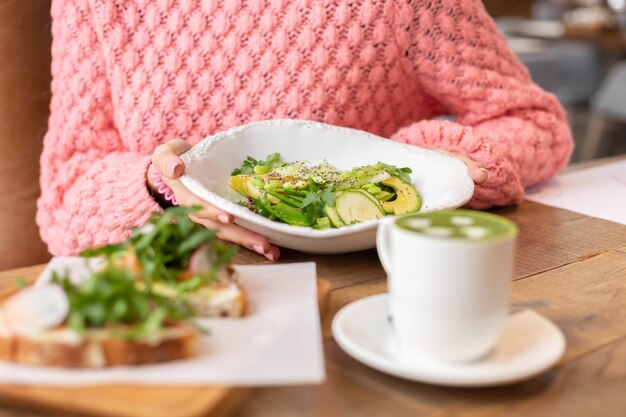 Sana colazione al ristorante. Insalata verde, bruschetta con rucola e salmone e latte matcha