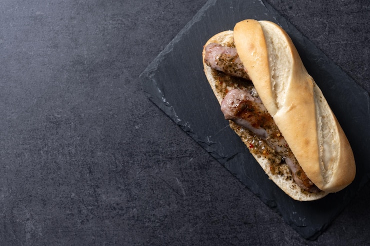 Foto gratuito sandwich tradizionale argentino choripan con salsa chorizo e chimichurri su sfondo di ardesia nera