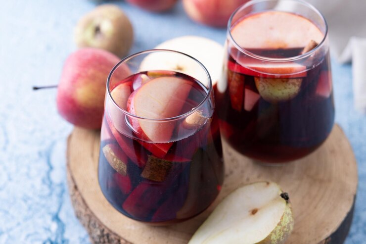 Foto gratuito sangria autunnale con pera e mela sulla tavola di legno