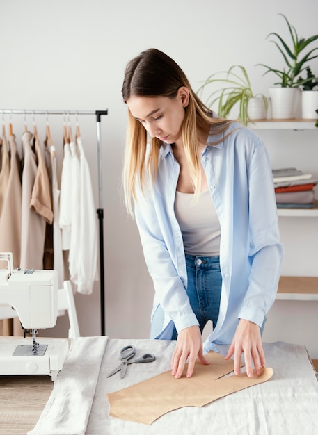 Sarto femminile che prepara tessuto per indumenti