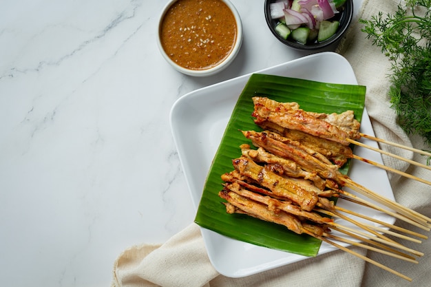 Satay di maiale con salsa di arachidi o salsa agrodolce, cibo tailandese