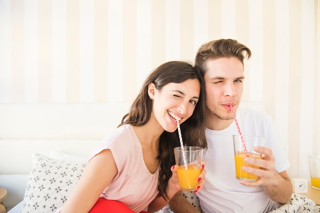 Sbattere le palpebre le coppie che posano con il succo