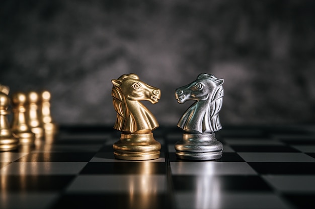 Scacchi dell'oro e dell'argento sul gioco di scacchiera per il concetto di direzione della metafora di affari