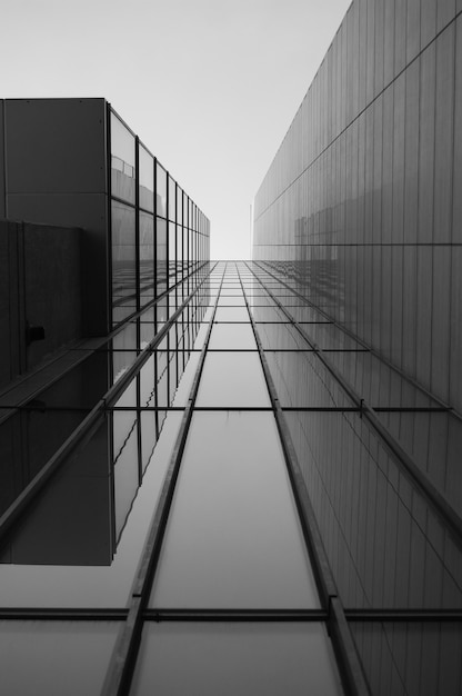 Scala di grigi di un tetto di un edificio moderno con finestre di vetro sotto la luce del sole