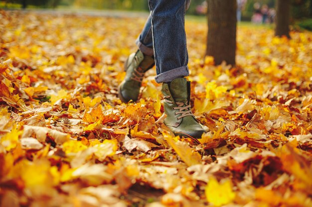 Scarpe di cuoio che camminano sulle foglie di caduta all'aperto