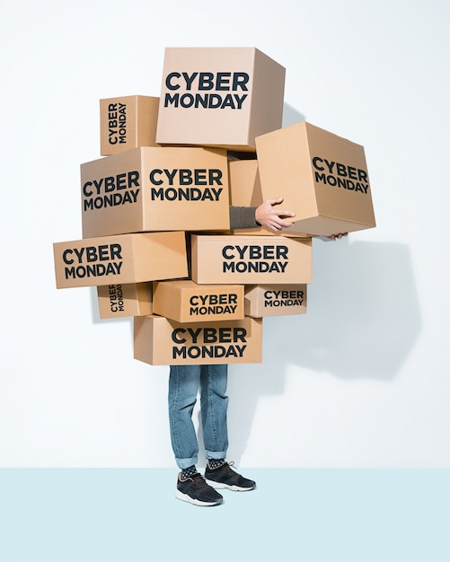 Scatole di cartone con iscrizione Cyber Monday nelle mani di un giovane