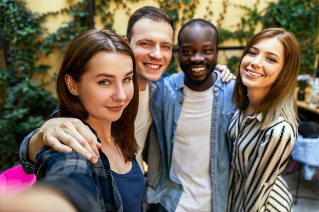 Scattare foto selfie con i migliori amici nella calda giornata di primavera presso l'accogliente ristorante