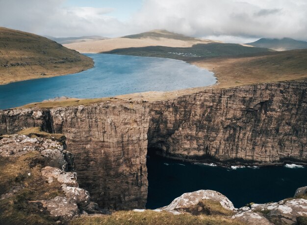 Scatto che cattura la splendida natura delle Isole Faroe, del lago, delle montagne e delle scogliere