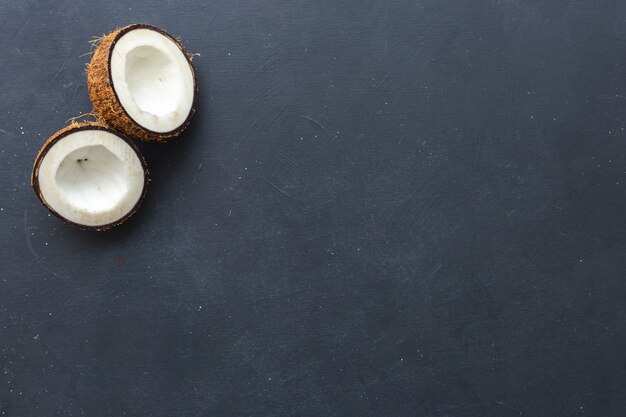 Scatto dall'alto di noci di cocco tagliate su uno sfondo grigio - perfetto per la carta da parati