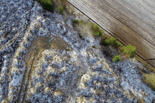 Scatto dall'alto di un campo agricolo con gocce di neve in campagna