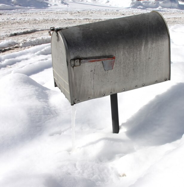 Scatto dall'alto di una cassetta postale d'argento con neve in superficie durante l'inverno