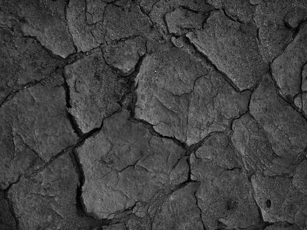 Scatto in scala di grigi di sfondo di struttura del suolo incrinato