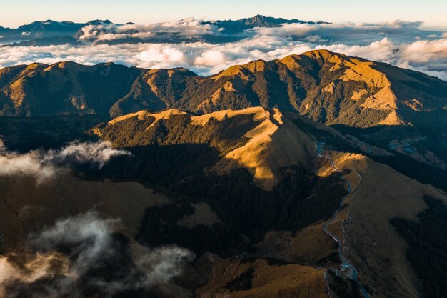 Scatto mozzafiato del paesaggio montuoso sopra le nuvole panoramiche