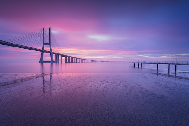 Scatto mozzafiato del ponte Vasco da Gama all'alba a Lisbona, Portogallo