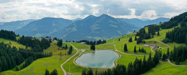 Scatto panoramico del Filzalmsee circondato da colline ricoperte di verde in Austria