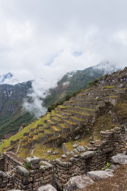 Scatto verticale di un'affascinante montagna Machu Pichu in una giornata nebbiosa