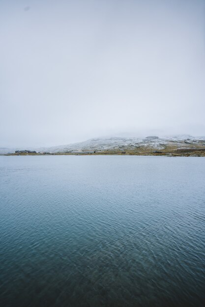 Scatto verticale di un bellissimo lago circondato da alte montagne a Finse, Norvegia