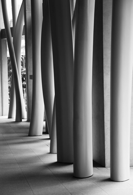 Scatto verticale in scala di grigi degli interni di un edificio moderno con colonne storte