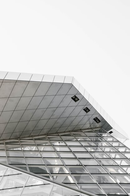 Scatto verticale in scala di grigi di una struttura geometrica catturata da un angolo basso