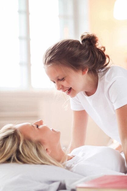 Scena familiare. Felice madre e figlia in un letto