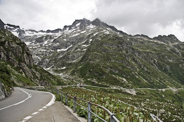 Scenario affascinante della bellissima strada tra le montagne sotto un cielo nuvoloso