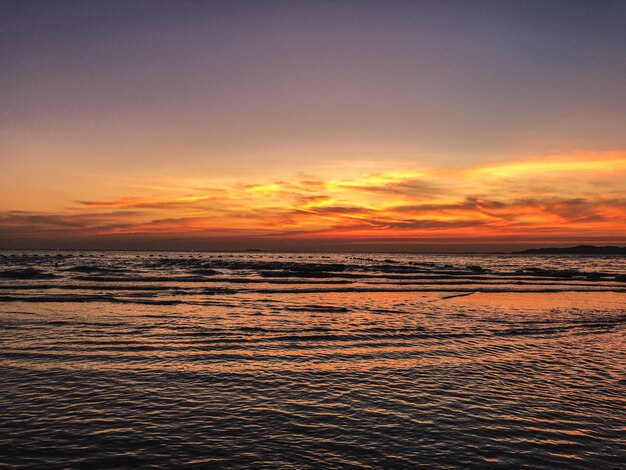 Scenario del tramonto sulla spiaggia con rilassanti onde dell'oceano