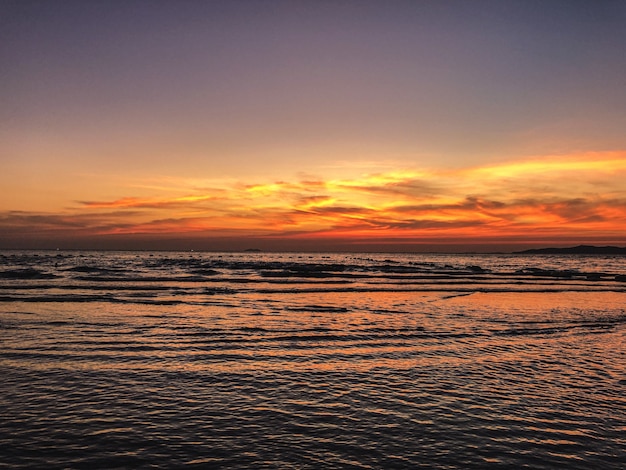 Scenario del tramonto sulla spiaggia con rilassanti onde dell'oceano