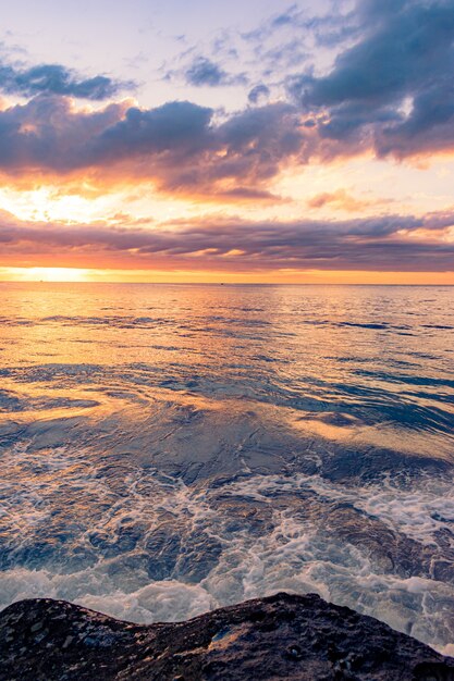 Scenario mozzafiato di una spiaggia rocciosa su uno sfondo bellissimo tramonto