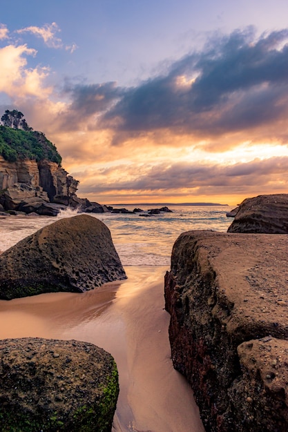 Scenario mozzafiato di una spiaggia rocciosa su uno splendido tramonto