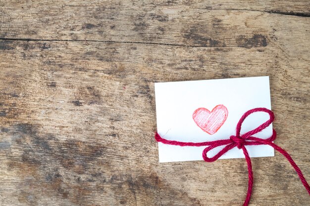 Scheda di San Valentino con mano disegnata cuore rosso e corda rossa