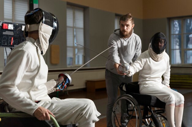 Schermitori disabili in attrezzatura speciale che combattono dalle loro sedie a rotelle