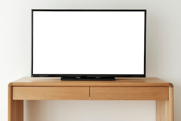 Schermo televisivo bianco vuoto su un tavolo di legno