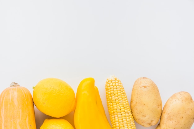 Schiacciare; Limone; peperone; pannocchia di mais e patate su sfondo bianco