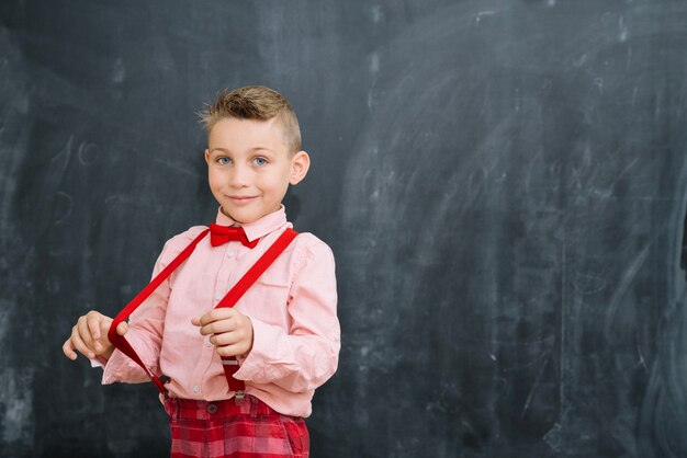 Schoolboy tirando parentesi graffe alla lavagna