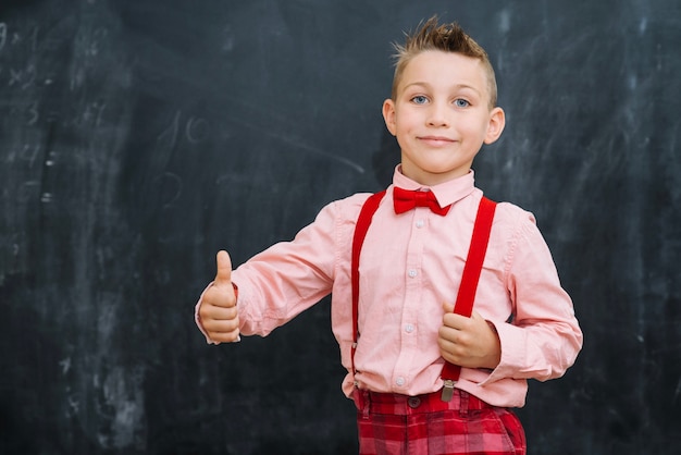 Schoolkid mostrando il pollice in su il gesto